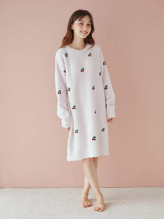 Woman wearing Cherry Pattern Jacquard Lounge Dress made of AIRY MOCO fabric for a soft, airy feel, standing against a peach background.