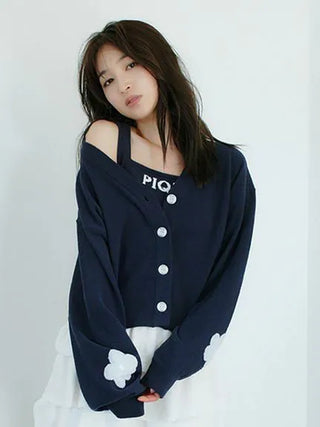 Model wearing navy Airy Moco Flower Logo Jacquard Cropped Tank Top with white floral detailing, showcasing stylish comfort.