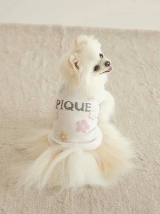 Small dog wearing CAT&DOG Flower Logo Jacquard Pullover with floral design, looking away on a light-colored surface.