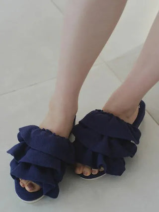 Person wearing dark blue Airy Moco Tiered House Slippers with ruffled design, showcasing the cozy and stylish indoor footwear.