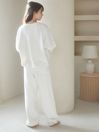 Woman wearing a fluffy Baby Moco CAT JQD pullover sweater in white, featuring a soft texture and relaxed fit, standing in a minimalist room.
