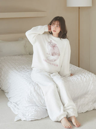 Person wearing a soft, fluffy Baby Moco CAT JQD pullover sweater with Siberian cat design, sitting on a bed in a cozy, neutral-colored room.