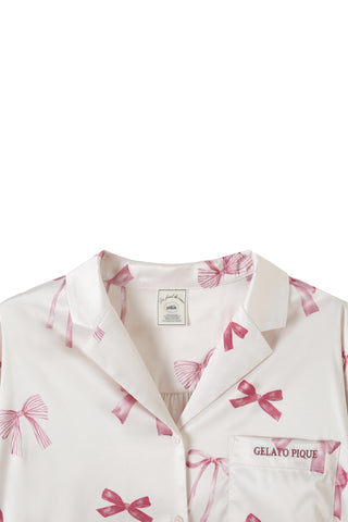 Elegant ribbon print shirt with pink bows and notched collar, featuring button closure and "Gelato" embroidery on the pocket.
