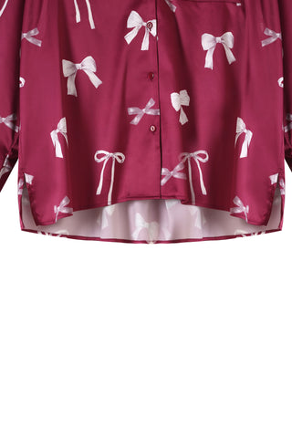 Close-up of a pink ribbon shirt with white bow print and button closure, part of the Ribbon Shirt & Long Pants Set.