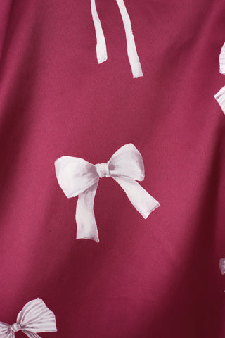 Close-up of white ribbon print on pink fabric from the Ribbon Shirt & Long Pants Set, showcasing elegant and feminine design.