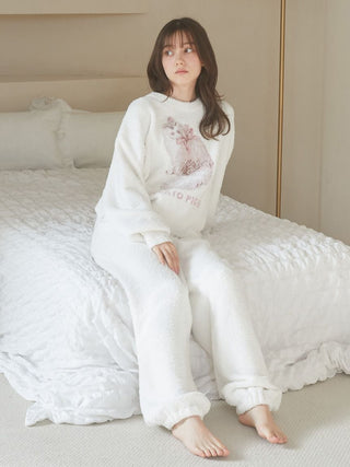 Woman wearing a Baby Moco CAT JQD Pullover Sweater with a Siberian cat design sitting on a bed in a cozy room.