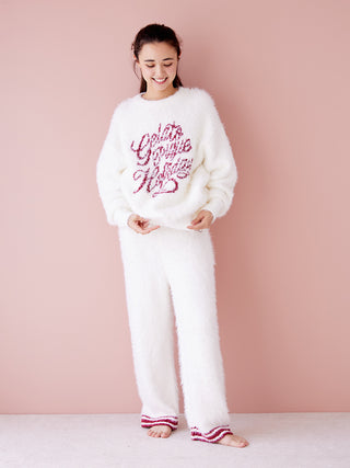 Woman wearing a white feather pullover sweater and matching pants, perfect for festive elegance and cozy comfort.