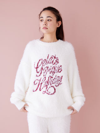 Model wearing Feather Pullover Sweater, white with burgundy festive text, showcasing cozy and elegant holiday fashion.