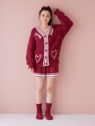 Woman wearing feather-soft lounge shorts and matching cardigan, cozy loungewear, festive red outfit with heart details, winter comfort.