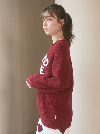 Model wearing Chocolate & Framboise pullover sweater by Gelato Pique USA, showcasing its fluffy Baby Moco fabric and bold logo.