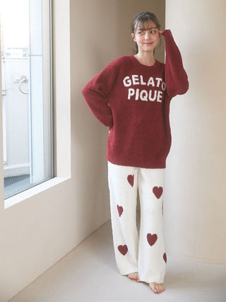 Woman wearing cozy Gelato Pique pullover sweater with fluffy pants, featuring heart patterns and relaxed loungewear style.