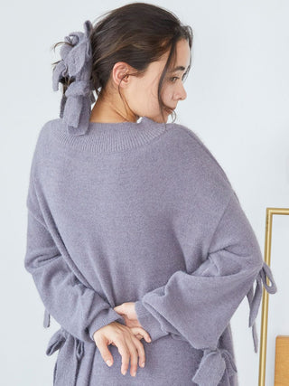 Woman wearing a gray sweater with a plush bow hair ribbon, featuring soft fabric and multiple bows for a voluminous stylish look.