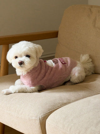 White dog wearing CAT&DOG Cupcake Sleeveless Pet Clothes in pink, lying on a beige chair.