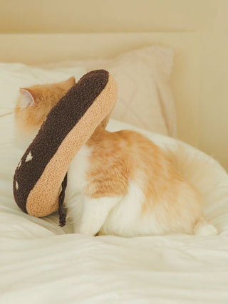 Cat wearing a donut-shaped Moco neck pillow on a bed, showcasing the CAT & DOG pet accessory for comfort and style.