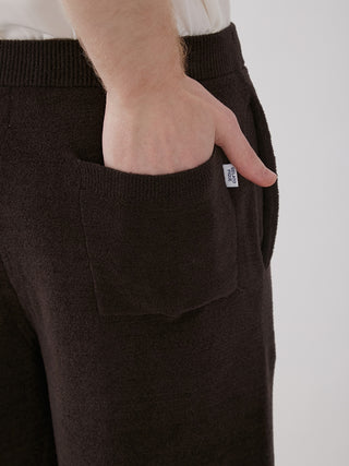 Close-up of a hand in the pocket of Men's Logo Jacquard Lounge Shorts, showcasing soft fabric and logo tag detail.