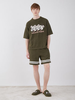 Man wearing KOUSUKE SHIMIZU Air Moco Lounge Shorts and shirt, showcasing GELATO PIQUE HOMME design collaboration, in a casual setting.