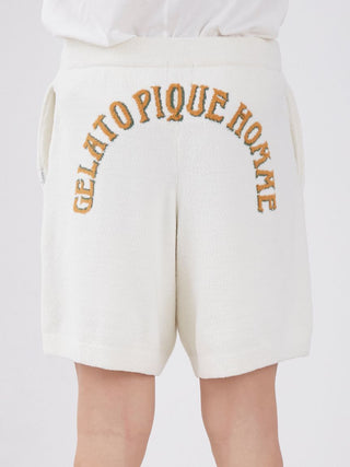 Back view of white lounge shorts with "Gelato Pique Home" embroidered in orange and green.