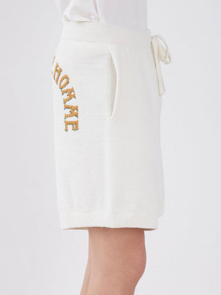 Side view of Air Moco Sleepy Bear Lounge Shorts in white with drawstring and side pockets, featuring cozy hotel-theme lettering design.