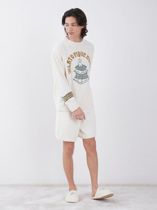 Model wearing Air Moco Sleepy Bear Lounge Shorts in a cozy, hotel-themed setting with bear motif, showcasing comfort and charm.