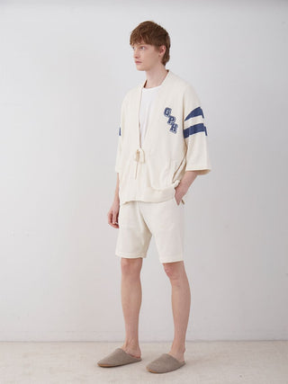 Model wearing Men's Air Moco College Lounge Shorts in cream, showcasing a comfortable and stylish loungewear outfit suitable for home or errands.