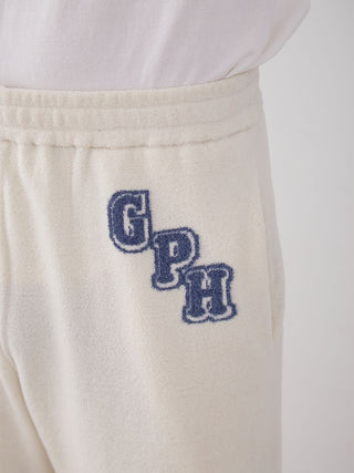 Close-up of Men's Air Moco College Lounge Shorts in cream with blue monogram 'GPH' embroidery, showcasing soft and breathable fabric.