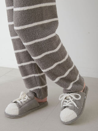 Man wearing Gelato Pique Powder Border Lounge Pants in gray with stripes, paired with soft slippers, showcasing comfort and style.