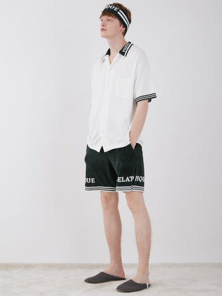 Model wearing a retro-inspired Smoothie Lite Tennis Logo Lounge Shirt with matching shorts and headband, embodying sporty chic style.