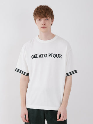Model wearing Smoothie Lite Tennis Logo Lounge Top for men, featuring retro design and Gelato Pique branding on white fabric.