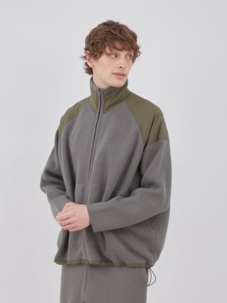 Model wearing OCEANS Plating Moco ECWCS Blouson Jacket in grey and olive green, showcasing luxury knit design.