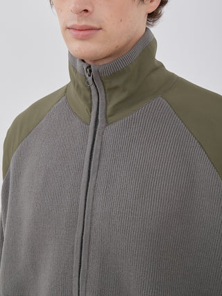 Close-up of men's Plating Moco ECWCS Blouson Jacket by Gelato Pique, featuring ribbed knit design and olive green accents.