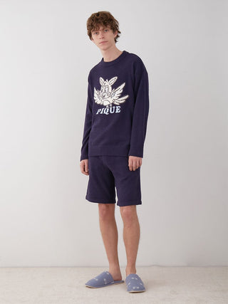 Man wearing navy KOUSUKE SHIMIZU Air Moco Pullover Sweater and shorts, showcasing cozy elegance and fashion.