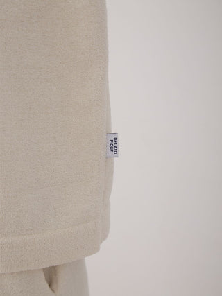 Detail of Men's Air Moco College Drop Shoulder Lounge T-Shirt in soft beige fabric with a subtle brand tag, showcasing texture and style.