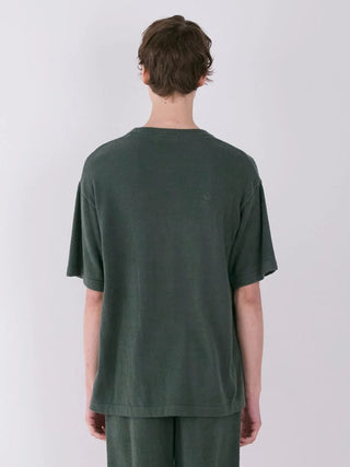 Back view of a person wearing a dark green short-sleeve fleece shirt and matching pants.