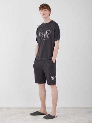 Man wearing black lounge shorts and matching t-shirt from Gelato Pique, standing against a plain background.