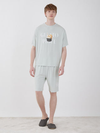 Man wearing Men's COOL Rayon Comfy Lounge Shorts in light green with matching shirt, standing on white carpet in casual setting.