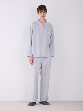 Model wearing GELATO PIQUE MEN'S satin shirt and pants in gray, showcasing luxurious loungewear with a classic button-down design.