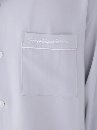 Close-up of men's satin shirt with elegant chest pocket and buttons, Gelato Pique branding, highlighting luxury loungewear design.