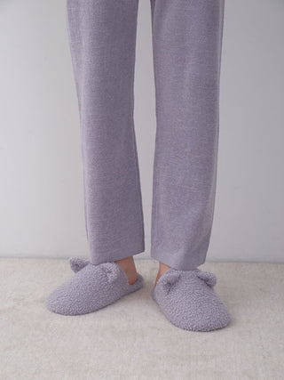 Man wearing grey Baby Moco Feather Cat Indoor Slip-On Shoes on a soft carpet, depicting comfort and cozy style.