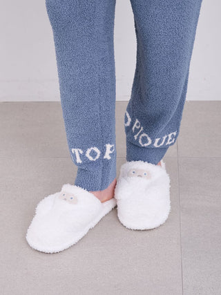 Alt Tag: Cozy white monster house shoes on person's feet wearing blue loungewear, made with soft, fluffy Gelato Pique fabric.