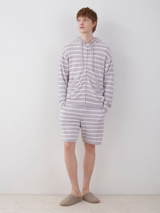 Man wearing men's smoothie striped pajama shorts and matching hoodie, showcasing casual comfort and style for lounging at home.