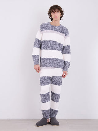 Man wearing cozy powder melange striped fuzzy pajama pants and matching top, standing indoors for a comfortable lounge look