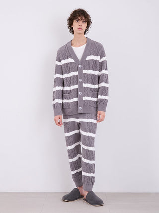 Man wearing gray and white striped cable knit pajama set with cardigan, showcasing cozy Baby Moco fabric, standing indoors.