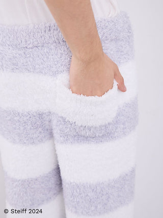 Close-up of Steiff Men's Gelato 2 Border Fuzzy Pajama Pants with wide striped pattern and a hand in pocket, showcasing soft fabric texture.