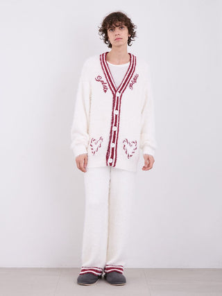 Model wearing cozy white pajama set with red trim and heart details, standing against a plain background.