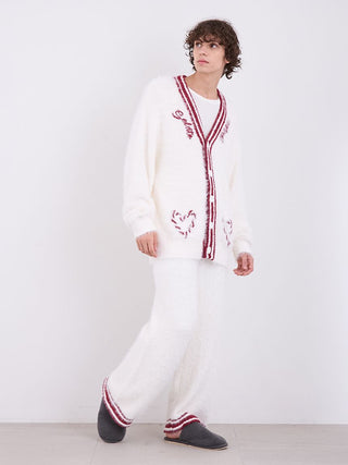 Model wearing mens feather pajama pants with cozy knitted cardigan, showcasing festive luxury and comfort.