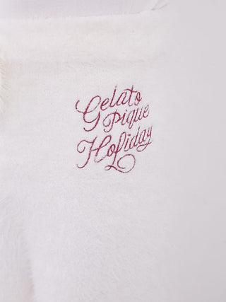 Close-up of embroidered text on soft feather material, showing 'Gelato pique Holiday' in festive red script.