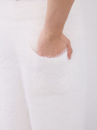 Close-up of hand in pocket of men's feather pajama pants, showcasing soft, fluffy fabric and cozy comfort.