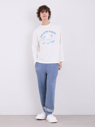 Model wearing Gelato Pique Mens Powder Logo Pajama Pants with white shirt, showcasing soft blue fabric and logo detail at cuffs.