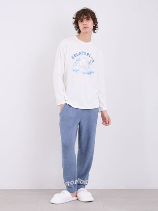 Model wearing Gelato Pique's blue Powder Logo Pajama Pants, featuring ultra-soft "Gelato" fabric and logo cuffs, paired with a white top.