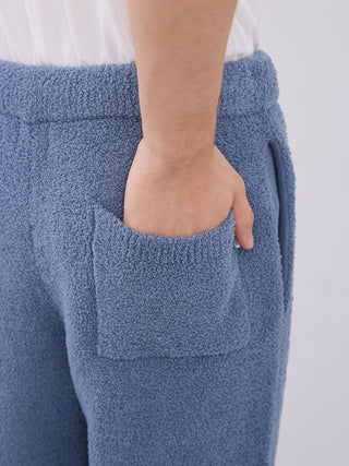 Close-up of men's blue pajama pants with soft texture, featuring a pocket and elastic waistband, showcasing comfort and style.